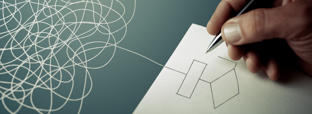 Expert business hand solving tangled line, outside the paper sheet on a blue desk